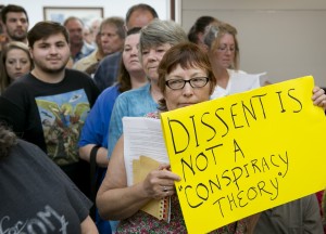 A woman who did not want her name published holds a sign at a public hearing about the Jade Helm 15 military training exercise at the Bastrop County Commissioners Court in Bastrop on Monday April 27, 2015.  An overflow crowd came to the meeting to hear a presentation and ask questions of  Lt. Col. Mark Lasatoria, of the U.S. Army Special Operations Command, about the controversial military exercise that will take place in several states this summer.   JAY JANNER / AMERICAN-STATESMAN