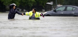 Alberto Lopez, right, helps his wife Glenda wade through floodwaters as they evacuate their flooded apartment complex Monday, April 18, 2016, in Houston. Storms have dumped more than a foot of rain in the Houston area, flooding dozens of neighborhoods and forcing the closure of city offices and the suspension of public transit. (AP Photo/David J. Phillip) ORG XMIT: TXDP117